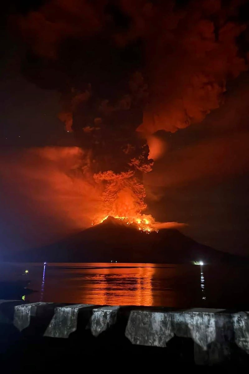 In this photo released by Sitaro Regional Disaster Management Agency (BPBD Sitaro), hot molten lava glows at the crater of Mount Ruang as it erupts in Sanguine Islands, Indonesia (BPBD Sitaro via AP)