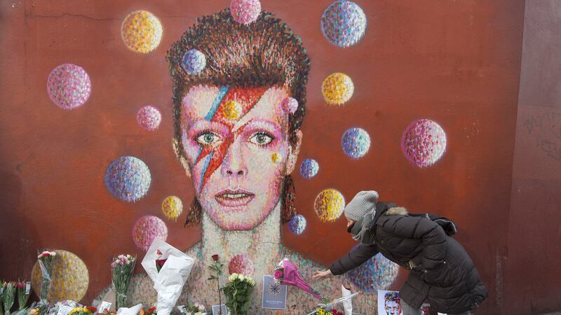 Flowers left below a mural of David Bowie in Brixton, London, the singers birthplace, after the rock star died in January 2016. Picture by Anthony Devlin, Press Association&nbsp;