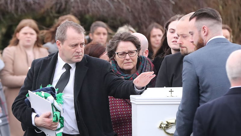 Andrew McGinley touches a coffin of one of his three children during the funeral of siblings, Conor, Darragh and Carla McGinley, at the Church of the Holy Family in Rathcoole, Dublin. Picture by Niall Carson/PA Wire&nbsp;