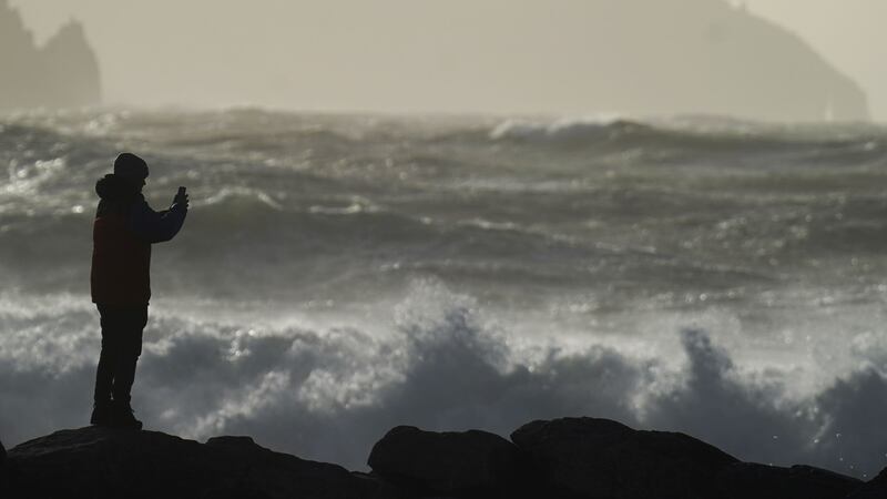 A person watching high waves in Doolin in County Clare on the west coast of Ireland (Niall Carson/PA)
