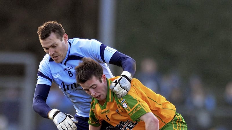 Donegal debut boy Eoin Wade is tackled by Ciaran Whelan as Jason Sherlock is grounded. 