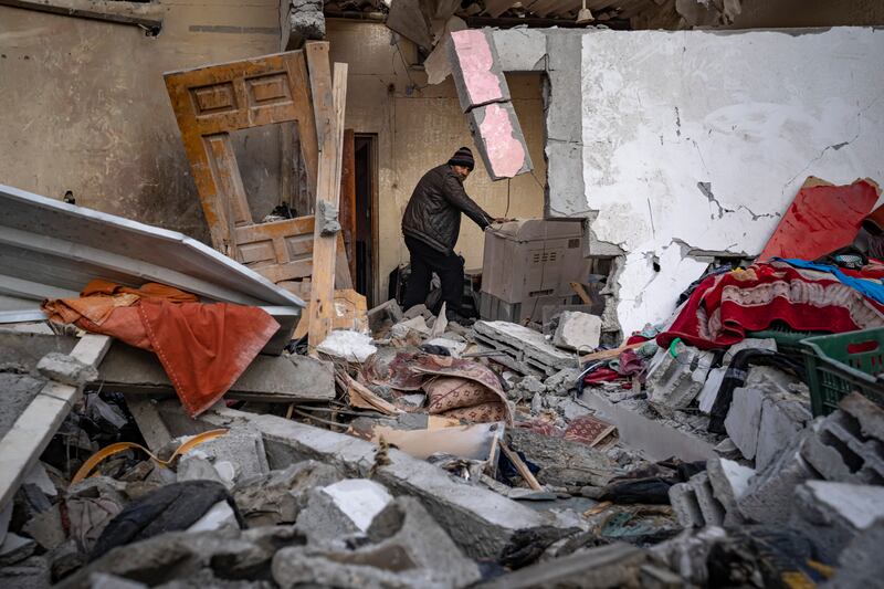 Palestinians inspect a house after it was hit by an Israeli bombardment on Rafah (AP)