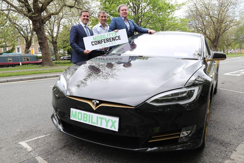 Martin Shanahan, CEO of IDA, left, Philip McNamara, VP of Voxpro and Dan Kiely, CEO of Voxpro, right, with a Tesla Model S car at a launch event for the MobilityX self-driving conference (Niall Carson/PA)