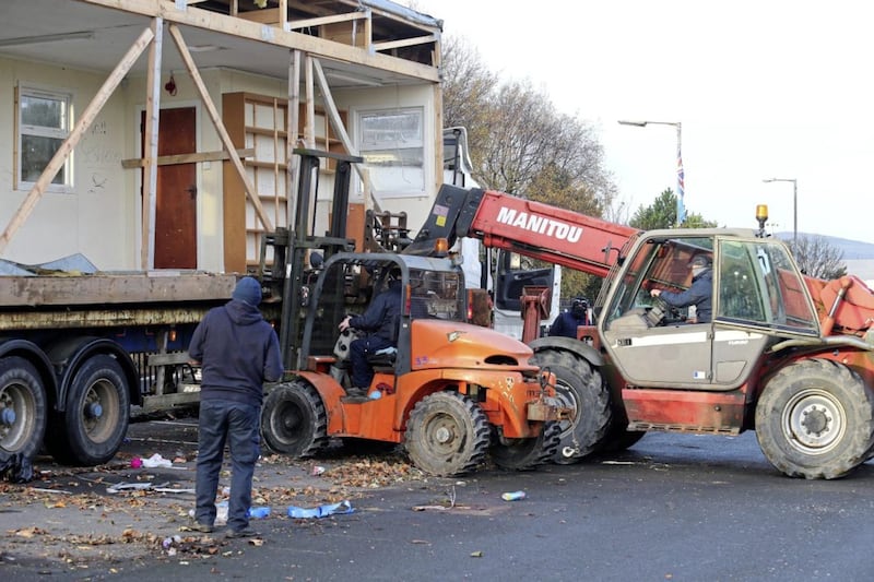 Masked contractors in east Belfast removing a portacabin on Belfast city council property. Picture Mal McCann. 