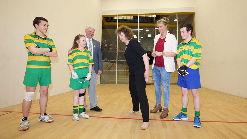 Sports minister Car&aacute;l N&iacute; Chuil&iacute;n demonstrates her skills after opening a new state-of-the-art handball centre at Col&aacute;iste Feirste on the Falls Road. Looking on are GAA president Aog&aacute;n &Oacute; Feargail, handball world champion Aisling Reilly and students from the school <br />Picture: Cliff Donaldson&nbsp;