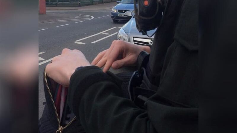 A video grab of a PSNI officer searching a teenage girl's schoolbag&nbsp;