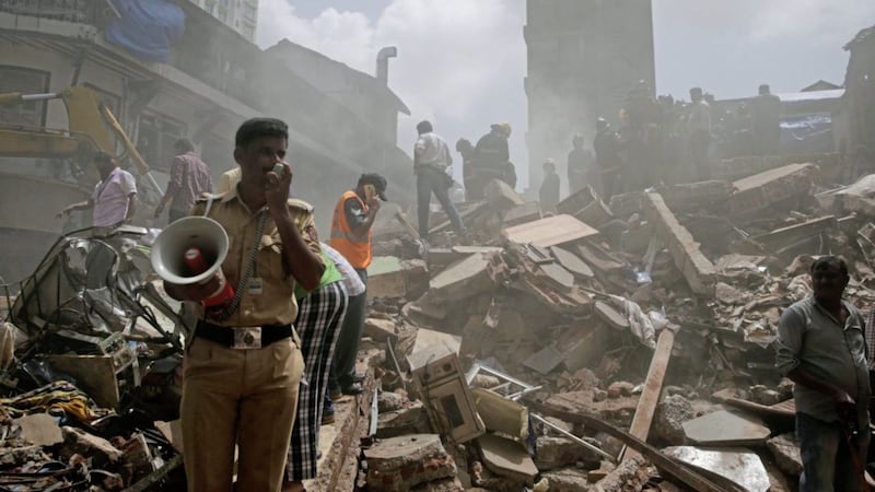A policeman makes an announcement on a loudspeaker at the site of building collapse in Mumbai, India, Thursday PICTURE: Rafiq Maqbool/AP 