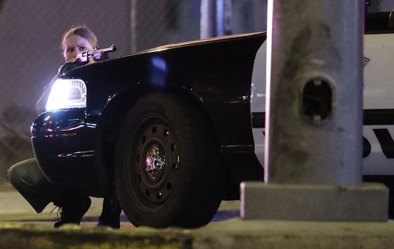 A police officer takes cover behind a police vehicle during a shooting near the Mandalay Bay resort and casino on the Las Vegas Strip&nbsp;