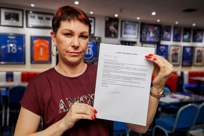 Lindsay Graham at Carrickfergus Glasgow Rangers Supporters Club holds her signed letter calling upon elected representatives to keep their word and remain outside of Stormont until the Irish Sea Border has been removed. Pictured date: Tuesday January 23 2024. See PA story ULSTER Letter. Photo credit should read: Liam McBurney/PA Wire