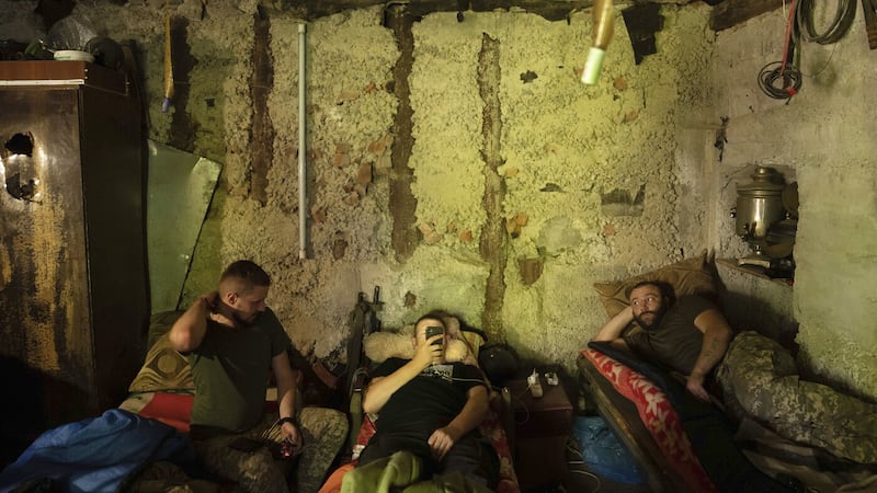 Ukrainian servicemen rest in a basement between fighting with Russian forces at the frontline in Kharkiv region, Ukraine, Wednesday July 27 2022 (AP Photo/Evgeniy Maloletka)
