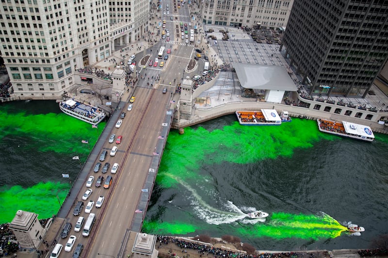 Boats move through the water as the Chicago River is dyed green for St Patrick's Day 