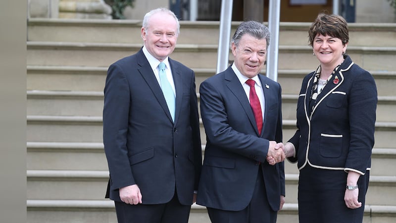 Deputy First Minister Martin McGuinness smiles and First Minister Arlene Foster shakes hands with Colombia's President Juan Manuel Santos&nbsp;