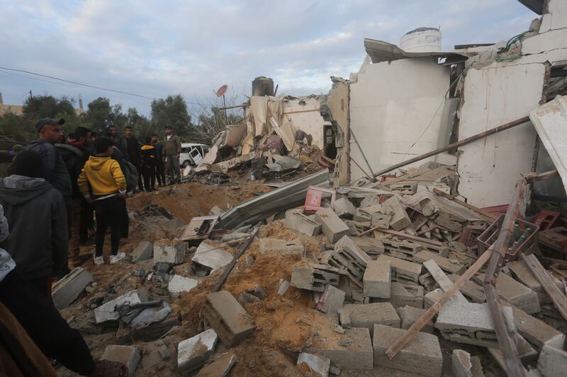 Palestinians look at a house destroyed in an Israeli strike in Rafah on Monday (AP Photo/Hatem Ali)