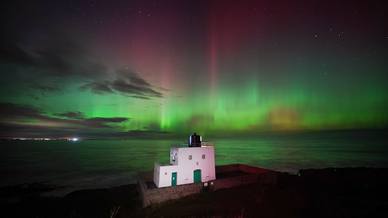 The aurora borealis, also known as the northern lights were seen over Bamburgh Lighthouse (Owen Humphreys/PA)