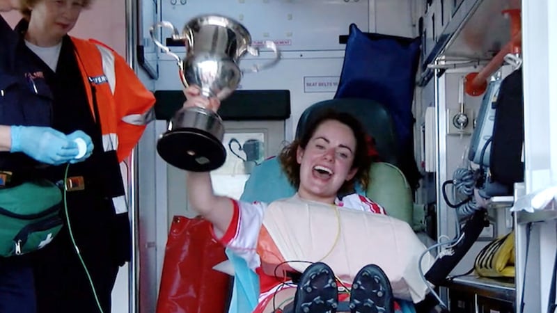 Injured Derry player Grace Conway lifts the trophy from an ambulance after being injured in the Ulster Junior final&nbsp;