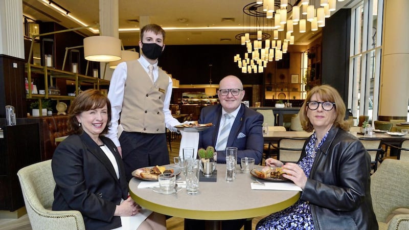 Waiter Conor Sullivan serves up breakfast in the Grand Central Hotel in Belfast to minister Diane Dodds, the hotel&#39;s general manager Stephen Meldrum and NI Hotels Federation chief executive Janice Gault. Picture: Arthur Allison/Pacemaker. 