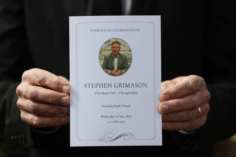A mourner holds the order of service for the the funeral mass of former BBC Northern Ireland political editor and director of communications at Stormont, Stephen Grimason, at Drumbeg Parish Church