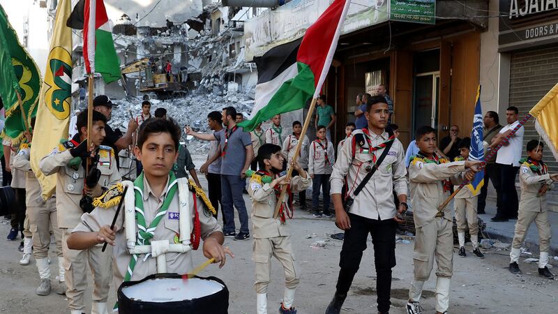 A Scout marching band pass a building destroyed by an Israeli airstrike, during a protest against a march by Jewish ultranationalists through east Jerusalem, along the streets of Gaza City, Tuesday, June 15, 2021 (AP Photo/Adel Hana)&nbsp;
