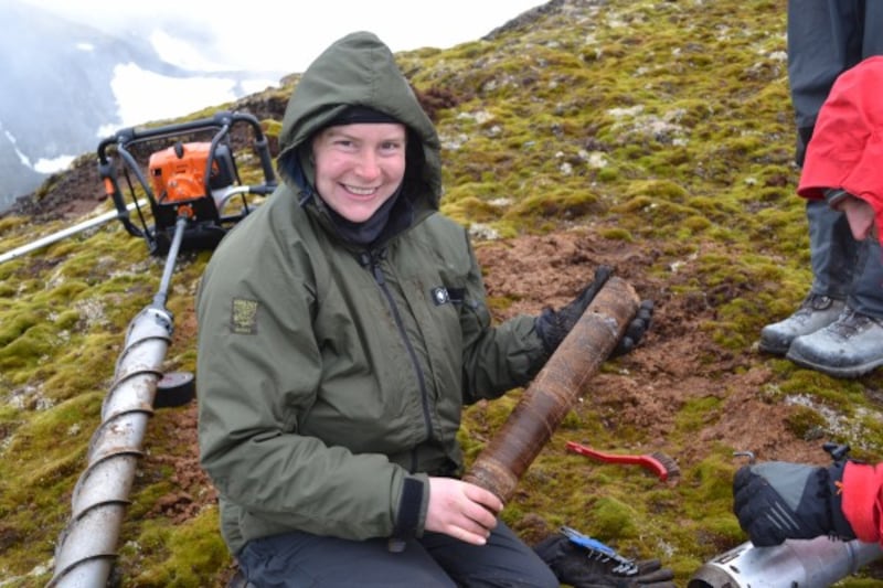 Team member Jessica Royles holding a frozen section of moss bank core.