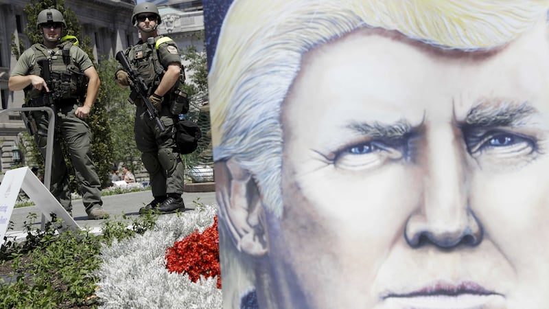 Law enforcement stands watch near a large poster of Republican presidential candidate Donald Trump at Public Square in Cleveland, during the second day of the Republican convention. Picture by Patrick Semansky, Associated Press&nbsp;