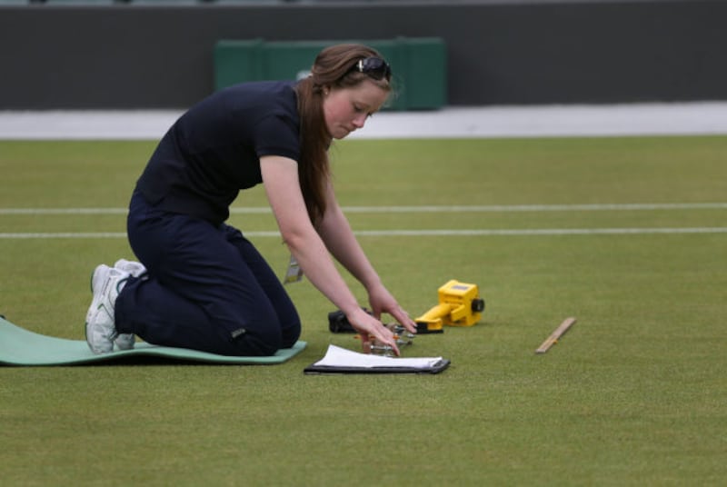 Laura Budimir, a research officer for the Sports Turf Research Institute checks live grass cover on Court 1 on day six of the Wimbledon Championships at the All England Lawn Tennis and Croquet Club, Wimbledon.