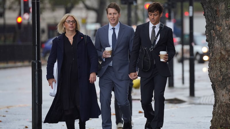 Dustin Lance Black, centre, arrives at Westminster Magistrates’ Court, with his husband Tom Daley, right (Lucy North/PA)