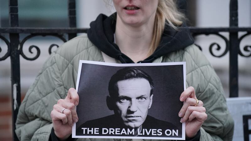 A protester holds a picture of Alexei Navalny at a protest opposite the Russian Embassy in London
