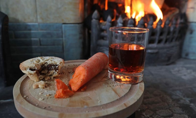 A mince pie, glass of sherry and a carrot for a reindeer is left by a fireplace (Owen Humphreys/PA)