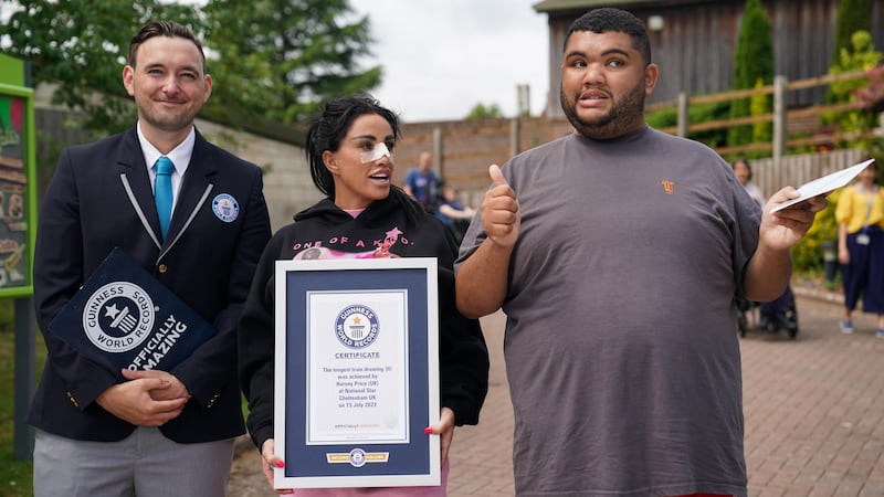 Guinness World Record adjudicator Will Munford, Katie Price and her son Harvey as he is presented with the Guinness World Record for the longest drawing of a train (Jacob King/PA)