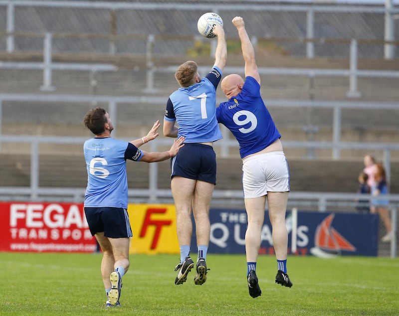 Mayobridge's Kevin McClorey in support as Cormac Linden challenges Jamie Grant of Warrenpoint in the air. 