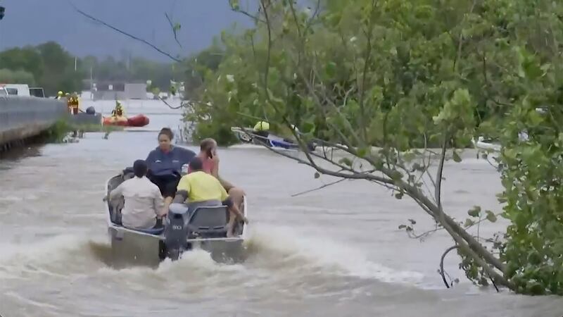 In this image from a video, people ride in boats in flooded river in Cairns, Australia (Australian Broadcasting Corp via AP)