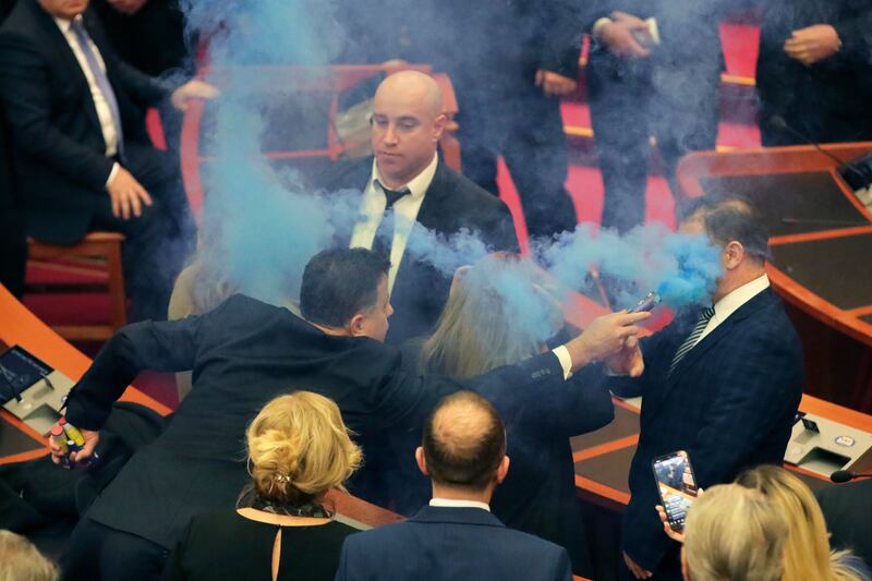 Flamur Noka, of the Democratic Party, points a smoke flare into the face of a bodyguard during a parliament meeting in Tirana, Albania, on Thursday (Armando Babani/AP)