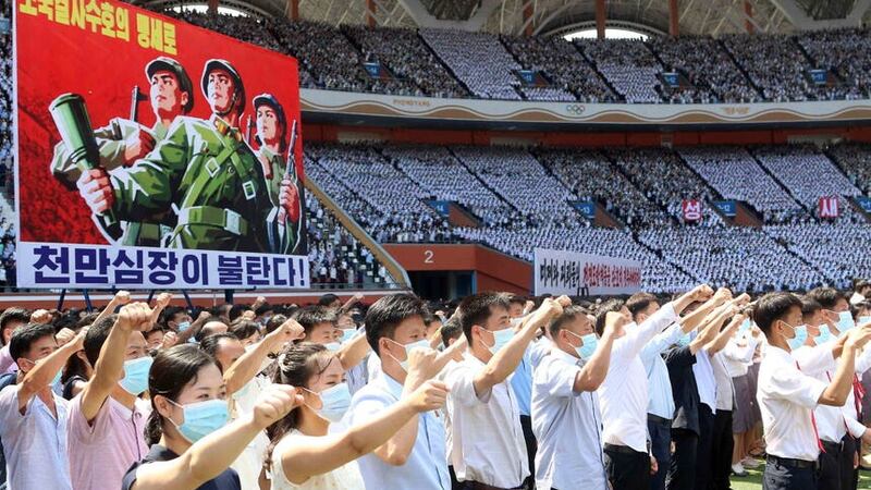 The poster reads “Tens of millions of people pledge to defy death for defending country!” (AP)