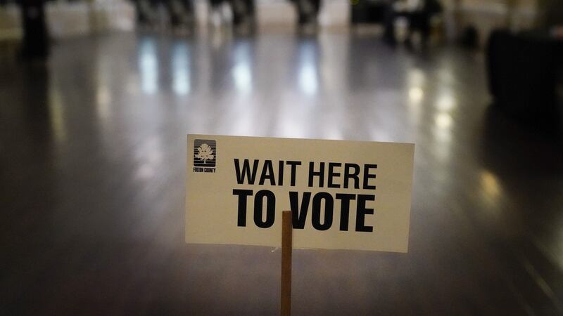 A sign is displayed for voters to guide the way at a precinct during Georgia's Senate runoff elections on Tuesday, Jan. 5, 2021, in Atlanta. (AP Photo/Brynn Anderson)