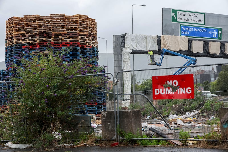 Heat resistant sheets have been wrapped around motorway signage near a bonfire in the Village area of south Belfast