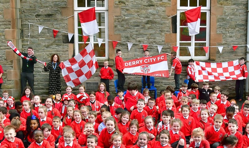 Getting the flags up at St Eugene's Primary School in Derry as players arrive to meet young city fans in the build-up to the FAI Cup Final this weekend Picture: Margaret McLaughlin 