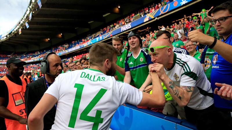 &nbsp;Northern Ireland's&nbsp;Stuart&nbsp;Dallas&nbsp;gives his boots away to a fan after the round of 16 match at the Parc de Princes, Paris<br />Picture by PA