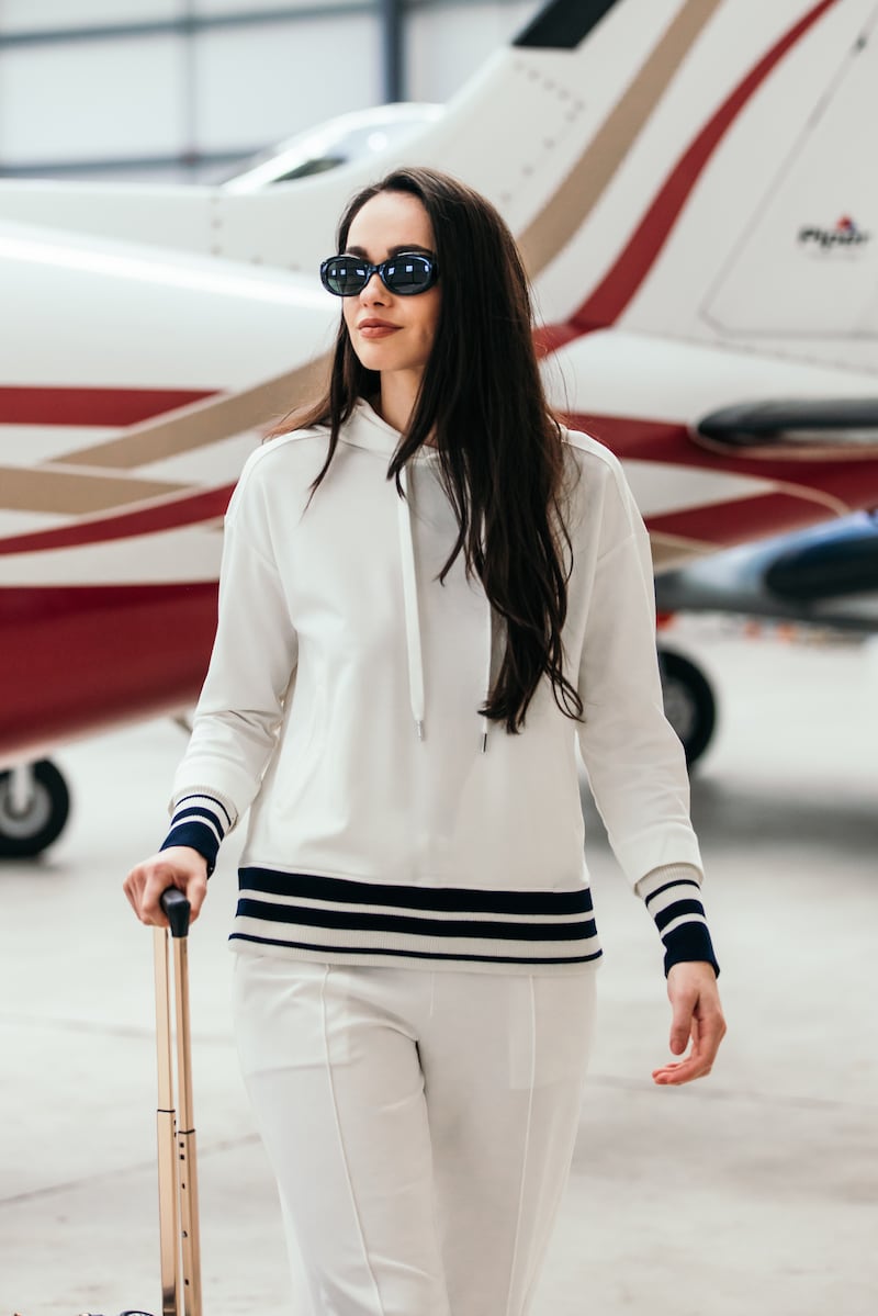 Model dressed in white beside aeroplane