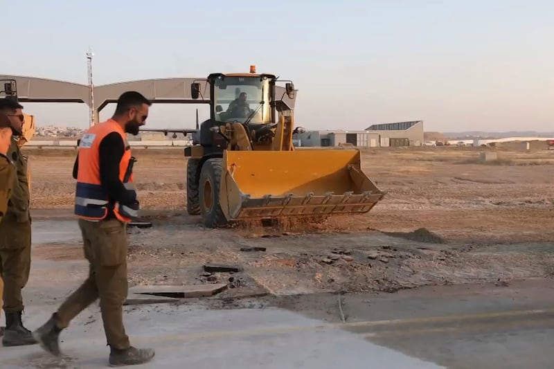 Workers repair a taxiway at Israel’s Nevatim air base (Israeli military via AP)