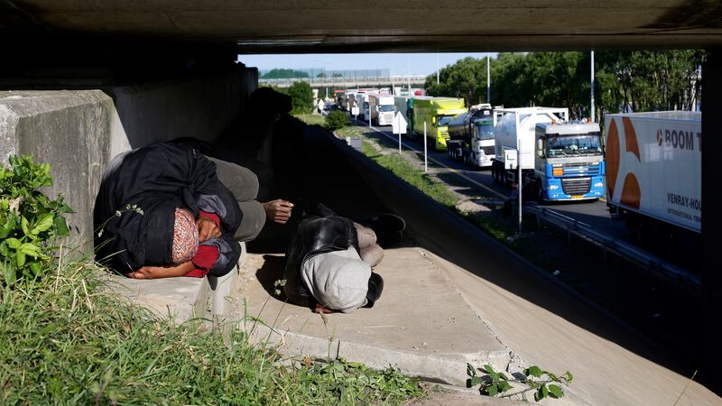 Migrants sleep under a motorway bridge alongside the road leading to the port of Calais. Picture by AP Photo