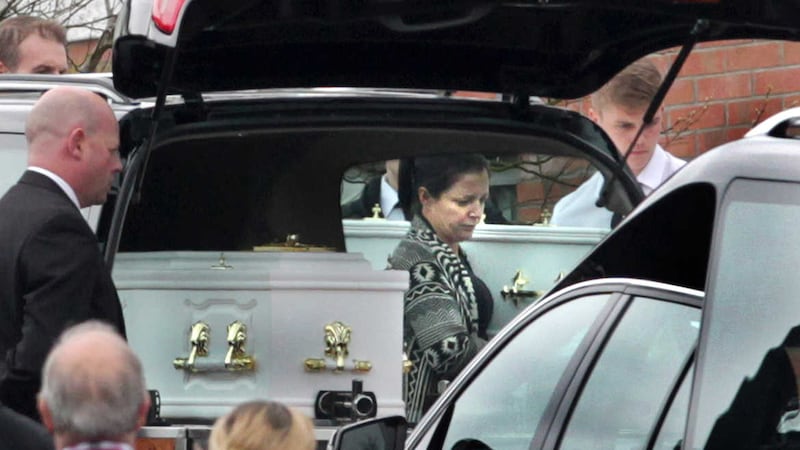 Louise James helps carry the remains of five members of her family into her home in Ballymagroarty. Picture by Margaret McLaughlin&nbsp;