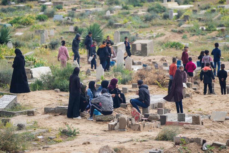 Palestinians visit the graves of their relatives who were killed in the war between Israel and the Hamas militant group on the first day of the Muslim holiday of Eid al-Fitr, in Deir al-Balah, Gaza (Abdel Kareem Hana/AP)