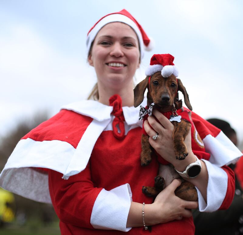 Lizzie Wall with Matilda, her 15-week-old Miniature dachshund, taking part in the London Santa Run in Victoria Park, east London