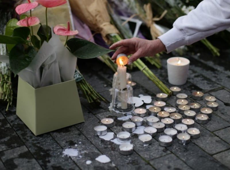 a candle being lit at a vigil in London (Yui Mok/PA)