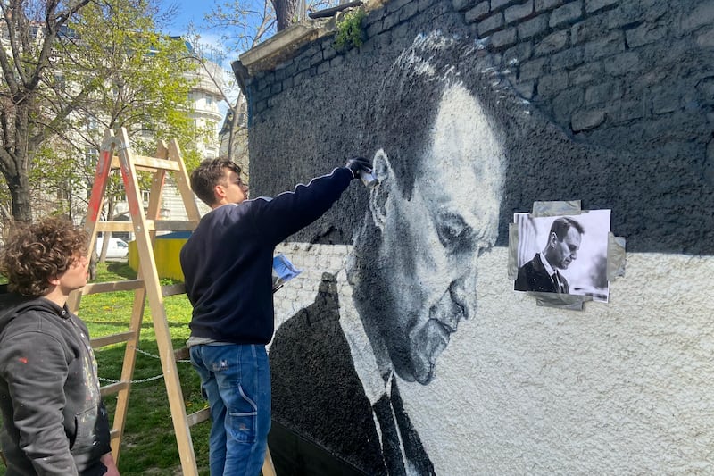 Austrian graffiti duo Joel Gamnou paints a picture of Alexei Navalny on a wall in Vienna, Austria (Philipp-Moritz Jenne/AP)