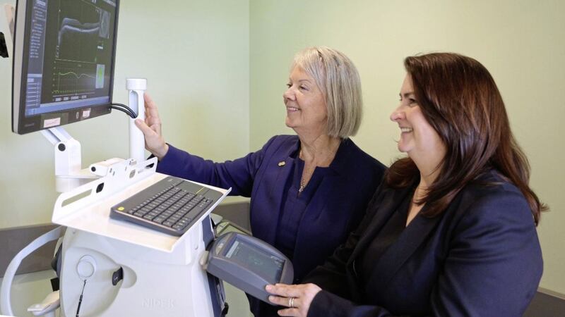 Specsavers co-founder Dame Mary Perkins (left) checks out the OCT machine at Specsavers in Strabane with Jill Campbell, head of enhanced optical services and ophthalmic director at Specsavers in Lisburn 