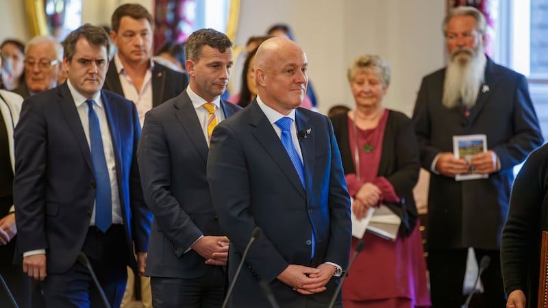 New Zealand Prime Minister Christopher Luxon, centre, stands during the swearing-in ceremony at Government House in Wellington (Mark Mitchell/New Zealand Herald/AP)