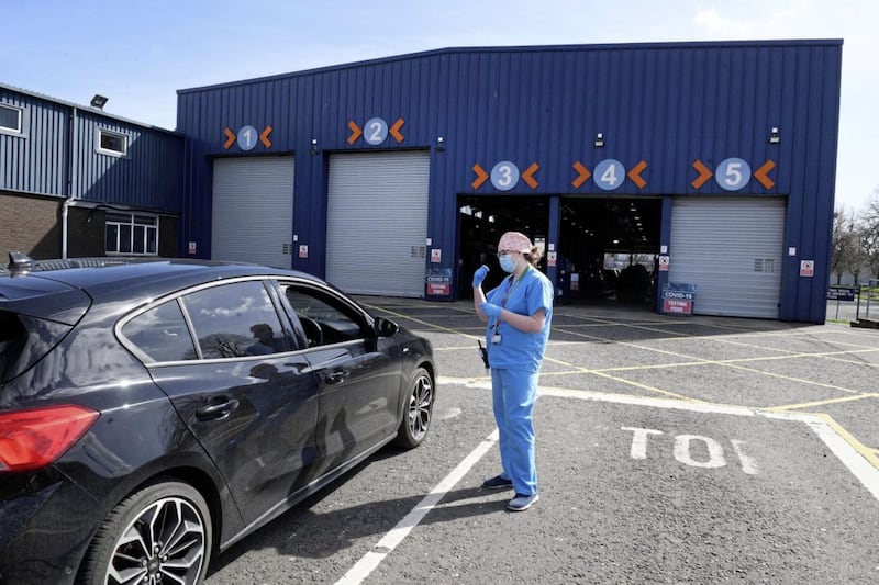 Medical staff direct cars at an MOT testing centre in Belfast, Northern Ireland, which is being used as a drive through testing location for Covid-19, as the UK continues in lockdown to help curb the spread of the coronavirus. PA Photo. Picture date: Tuesday April 7, 2020. See PA story HEALTH Coronavirus Ulster Testing. Photo credit should read: Justin Kernoghan/PA Wire. 