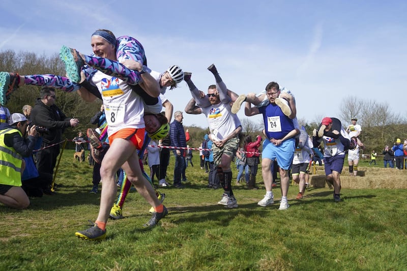 Competitors take part in the annual UK Wife Carrying Race at The Nower in Dorking, Surrey