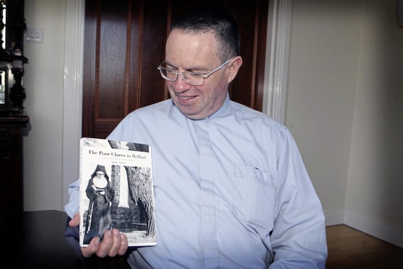 Fr Martin Magill with his new book about the story of the Poor Clares in Belfast  